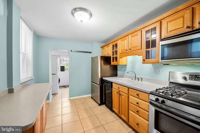 kitchen with light tile patterned floors, stainless steel appliances, and sink