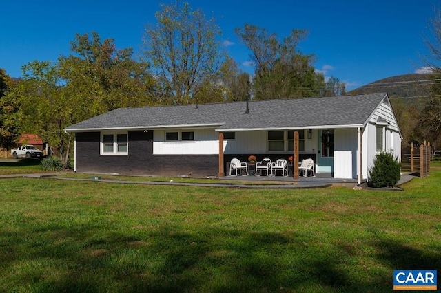 rear view of house with a lawn and a patio area