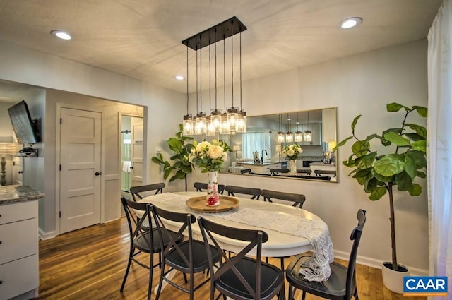 dining space with dark hardwood / wood-style flooring and sink