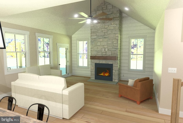 living room with a stone fireplace, ceiling fan, lofted ceiling, and light wood-type flooring