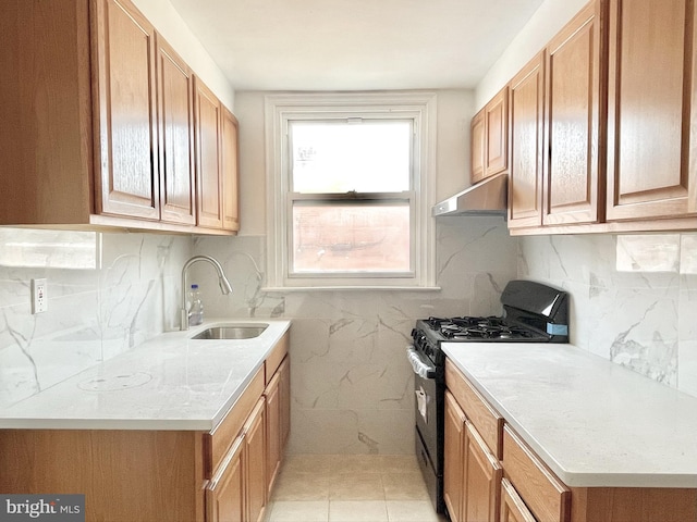 kitchen with light tile patterned floors, decorative backsplash, black gas stove, and sink