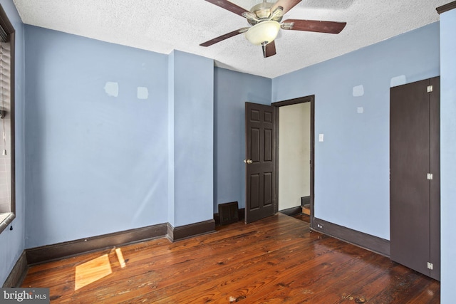 unfurnished room featuring a textured ceiling, ceiling fan, and dark hardwood / wood-style floors