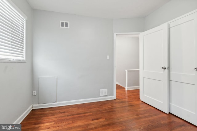 unfurnished bedroom with dark wood-type flooring