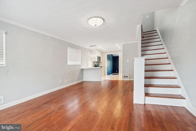 stairs featuring wood-type flooring and ornamental molding