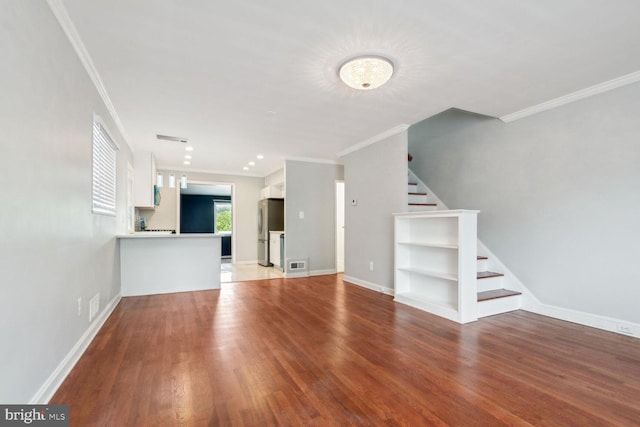 unfurnished living room with hardwood / wood-style floors and ornamental molding