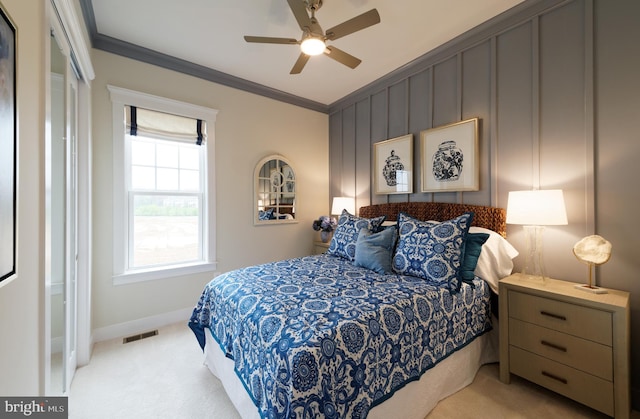 carpeted bedroom featuring ceiling fan, ornamental molding, and a closet