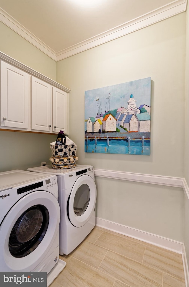 laundry area featuring cabinets, washer and clothes dryer, and ornamental molding