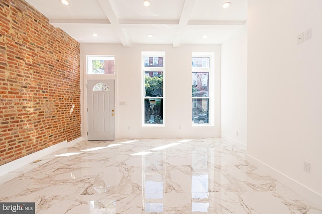 foyer featuring beam ceiling, a wealth of natural light, brick wall, and coffered ceiling