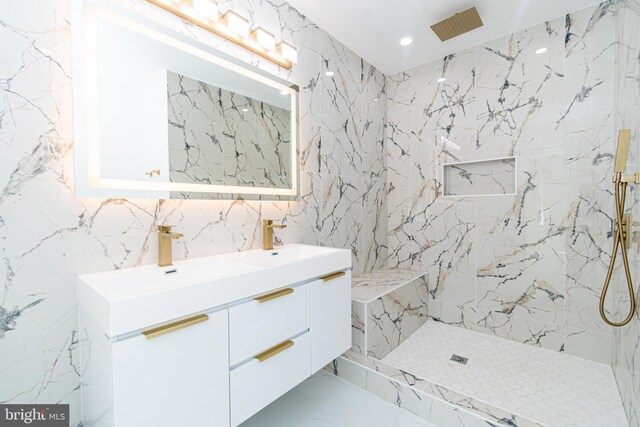 bathroom with a tile shower and vanity