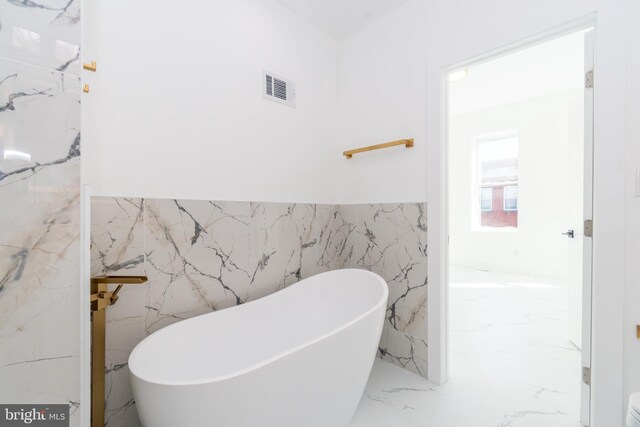 bathroom with a bath and tile walls