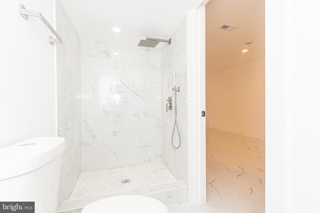 bathroom with toilet and tiled shower