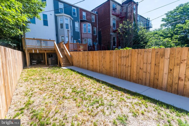 view of yard with a deck and central air condition unit