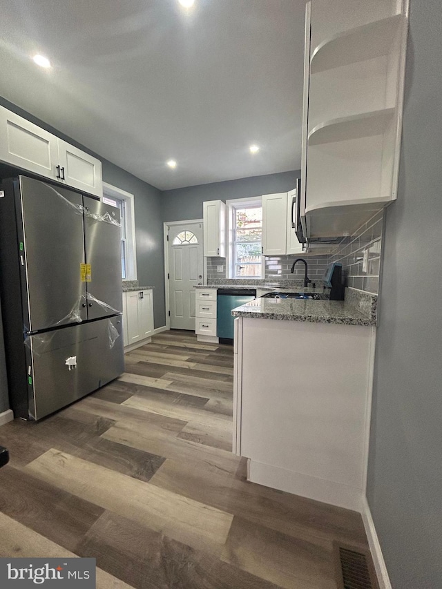 kitchen featuring white cabinets, appliances with stainless steel finishes, stone countertops, and dark hardwood / wood-style flooring