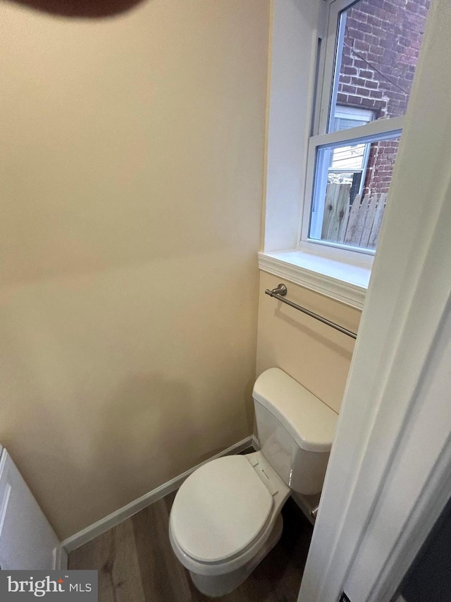 bathroom with hardwood / wood-style floors and toilet