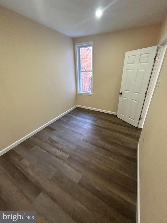 spare room with dark wood-type flooring