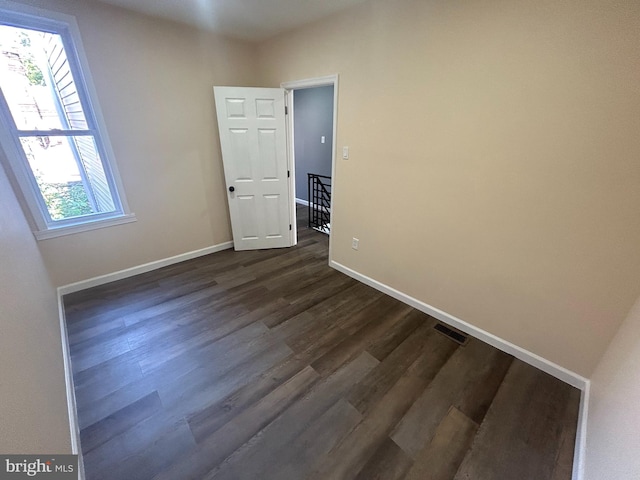 spare room with dark wood-type flooring