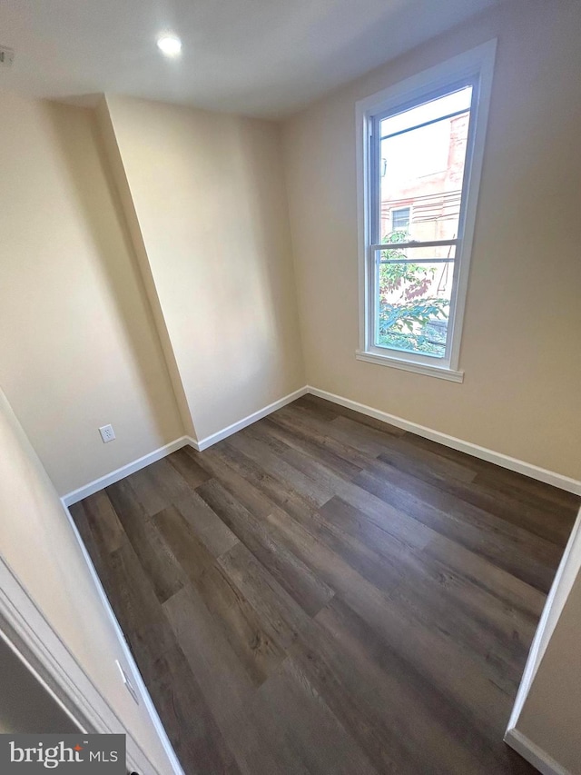 unfurnished room with dark hardwood / wood-style flooring