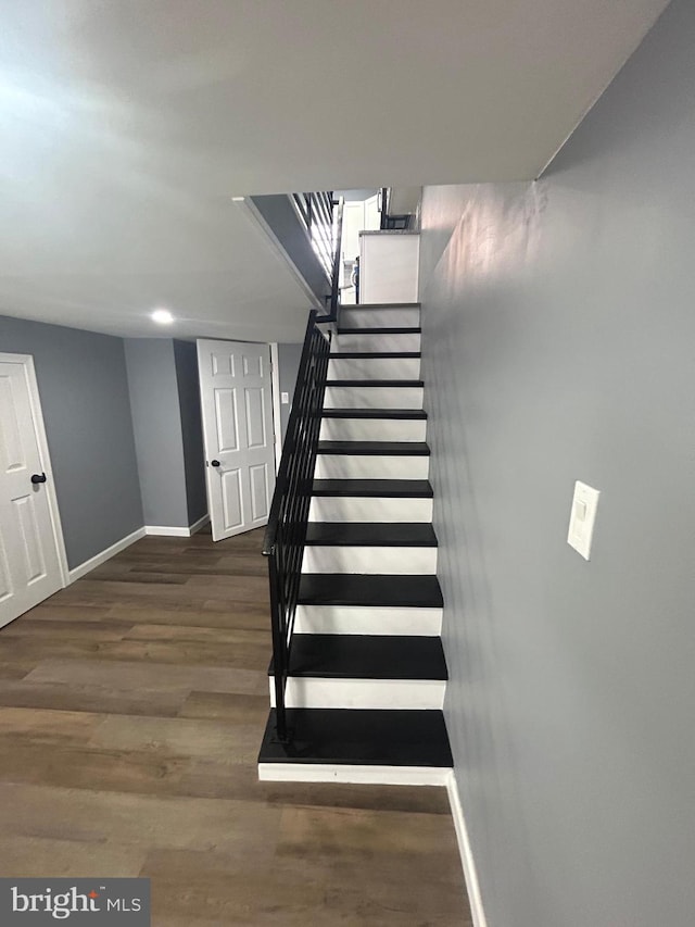 staircase with hardwood / wood-style flooring