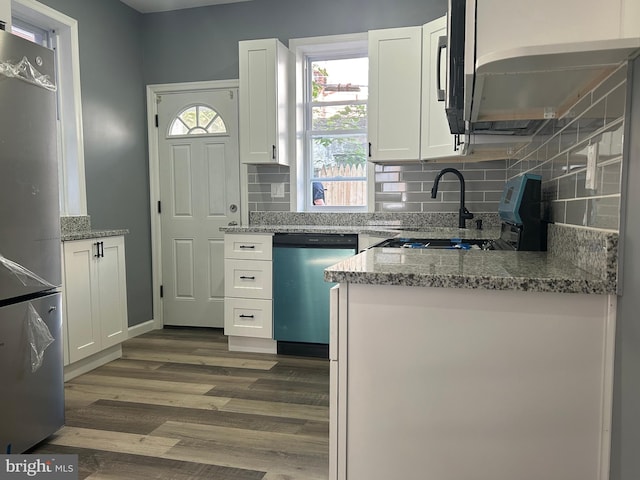 kitchen with light stone countertops, appliances with stainless steel finishes, dark hardwood / wood-style flooring, and white cabinetry