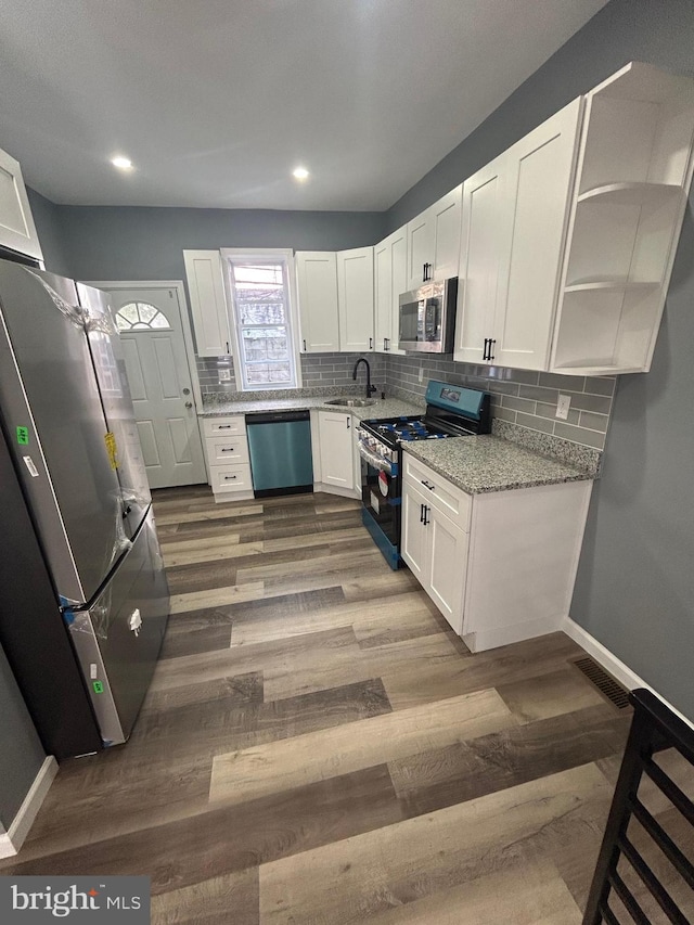 kitchen featuring white cabinetry, appliances with stainless steel finishes, dark wood-type flooring, and sink