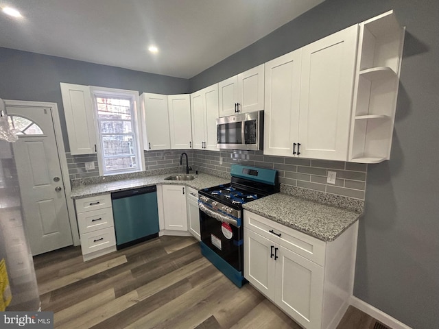 kitchen with sink, white cabinets, stainless steel appliances, dark hardwood / wood-style flooring, and light stone countertops