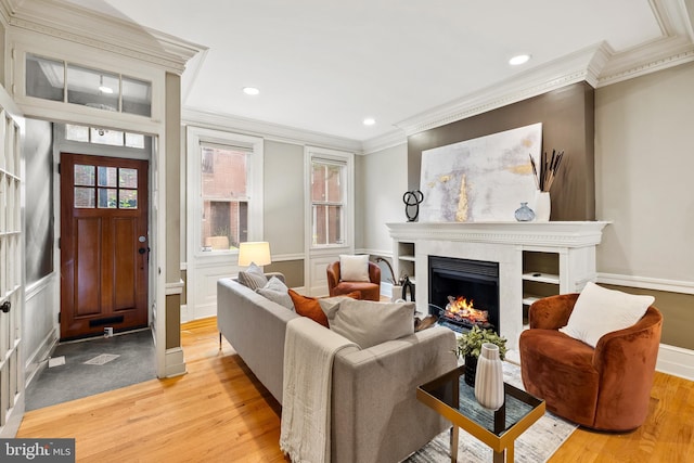 living area featuring light hardwood / wood-style floors and crown molding