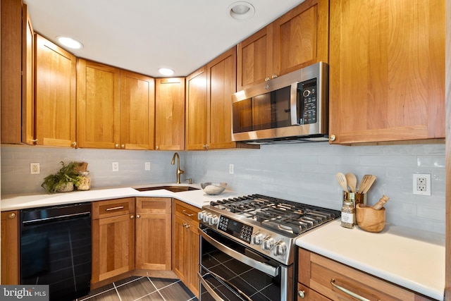 kitchen featuring stainless steel appliances, tasteful backsplash, sink, and dark tile patterned flooring