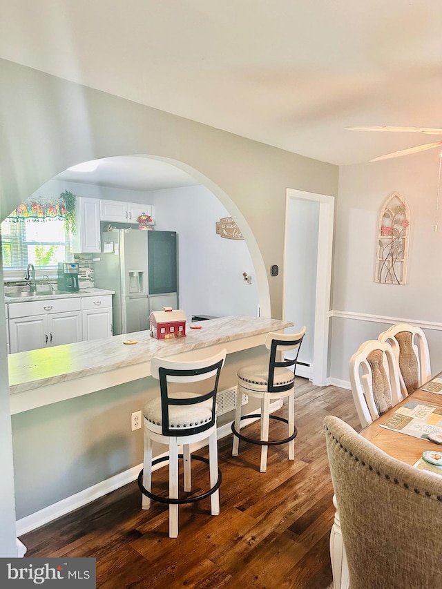 dining area featuring sink and dark wood-type flooring