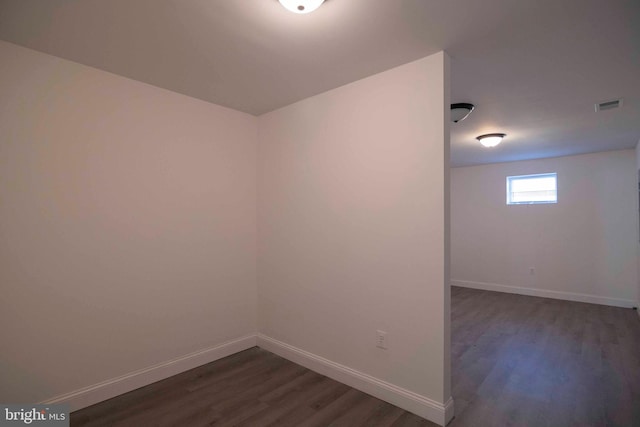 unfurnished room with dark wood-type flooring