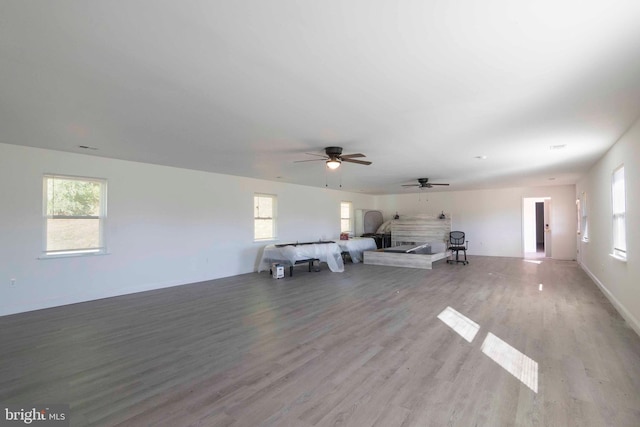 unfurnished living room featuring ceiling fan, a healthy amount of sunlight, and light wood-type flooring