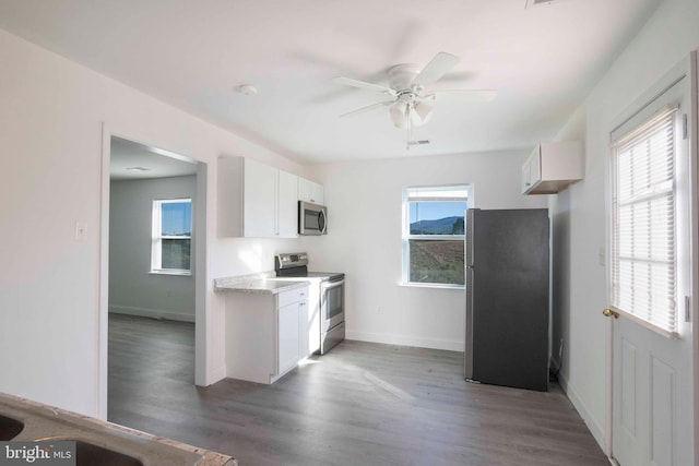 kitchen with ceiling fan, white cabinets, dark wood-type flooring, and appliances with stainless steel finishes