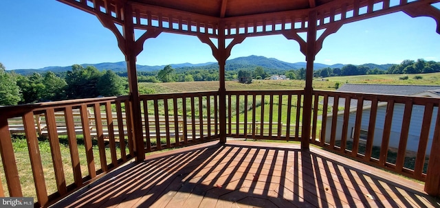 wooden terrace featuring a mountain view and a rural view