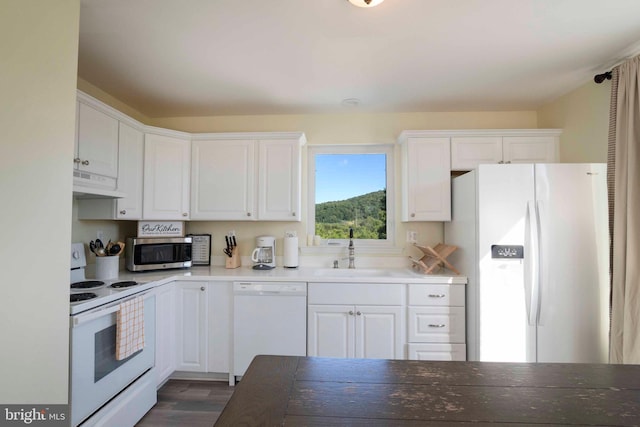 kitchen featuring white cabinetry, sink, dark wood-type flooring, range hood, and white appliances