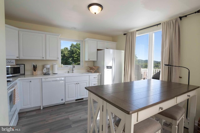 kitchen featuring white cabinets, white appliances, dark hardwood / wood-style floors, and sink