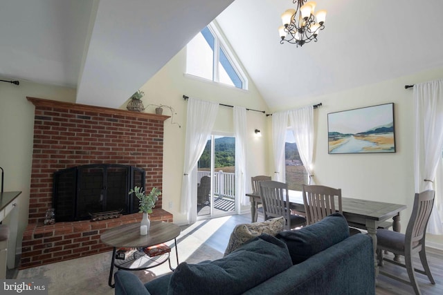 living room with a chandelier, a towering ceiling, and a brick fireplace