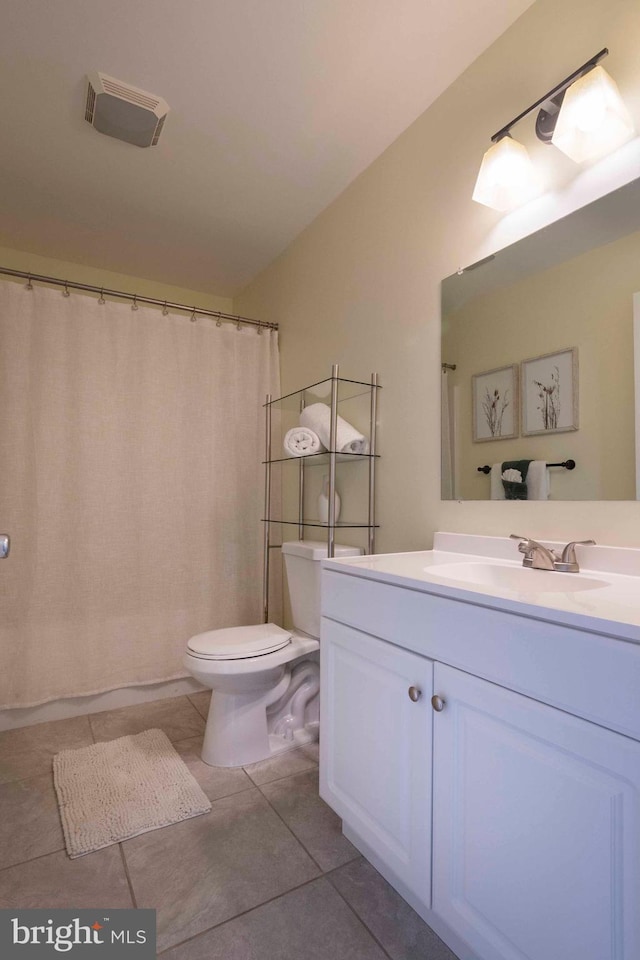 bathroom featuring walk in shower, tile patterned flooring, vanity, and toilet