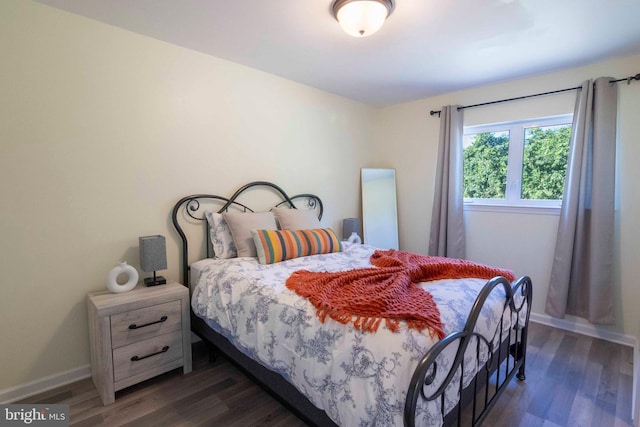 bedroom with dark hardwood / wood-style flooring