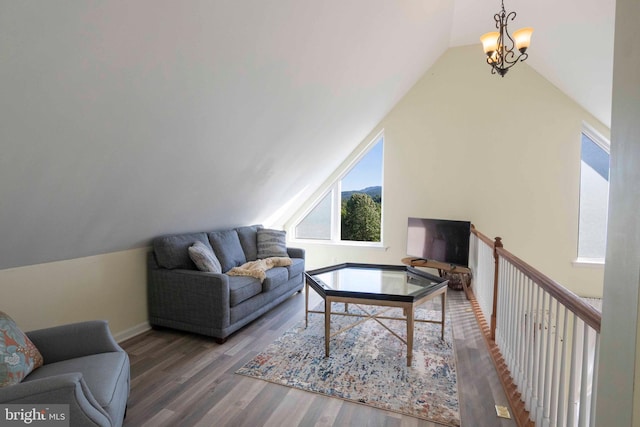 living room featuring hardwood / wood-style flooring, a notable chandelier, and vaulted ceiling