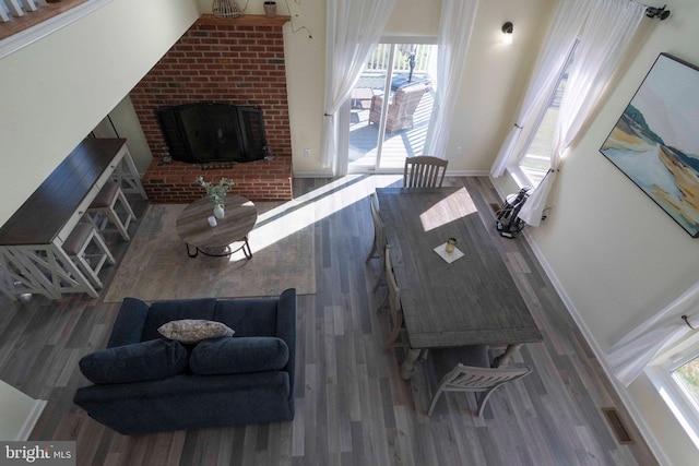 living room featuring hardwood / wood-style flooring and a brick fireplace