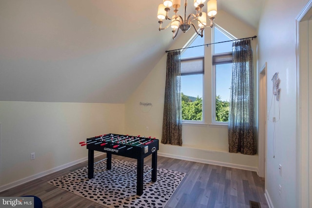 recreation room with dark wood-type flooring, lofted ceiling, and an inviting chandelier