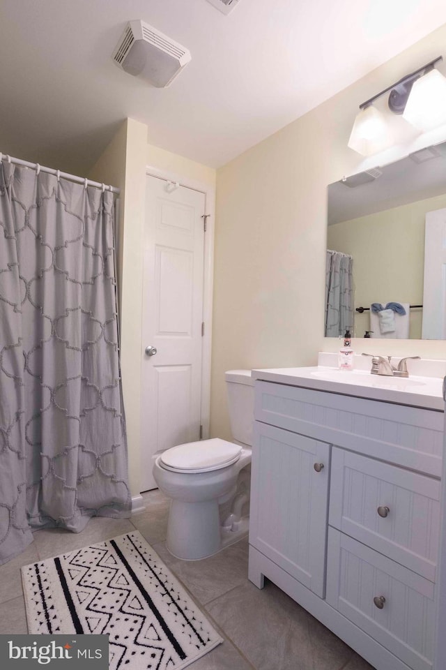 bathroom with tile patterned flooring, vanity, and toilet