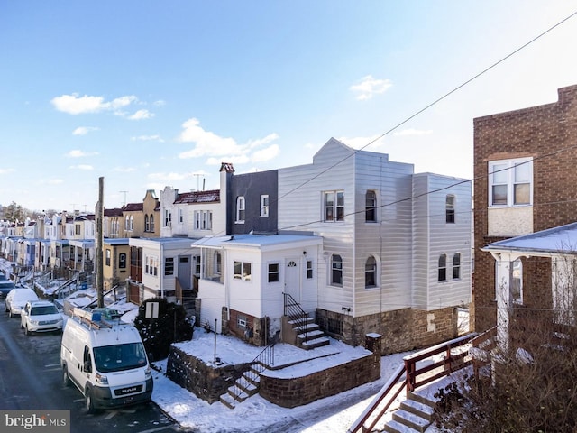 view of snow covered back of property