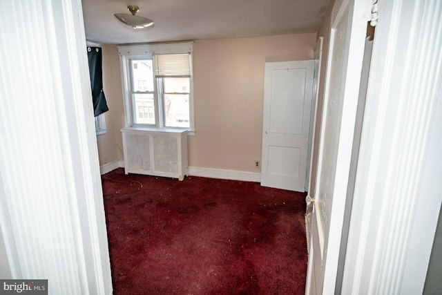 carpeted spare room featuring radiator heating unit