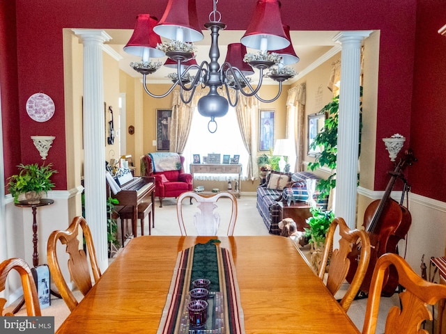 dining area featuring a chandelier, ornate columns, and crown molding