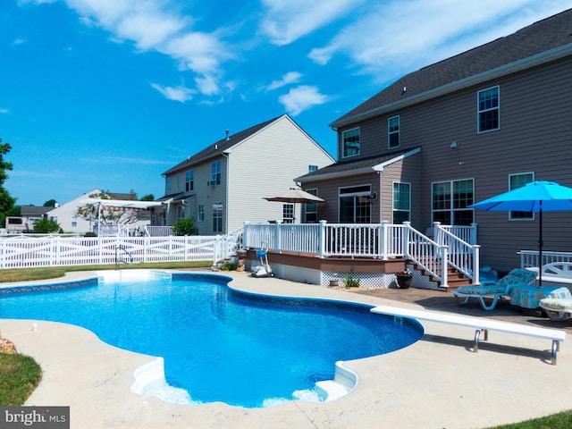 view of pool featuring a wooden deck and a diving board