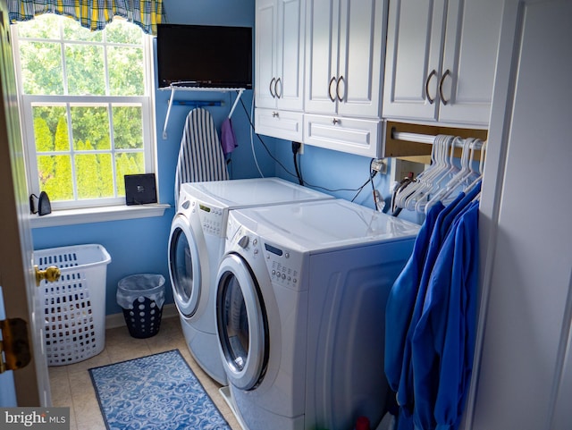 laundry area featuring light tile patterned flooring, cabinets, and independent washer and dryer