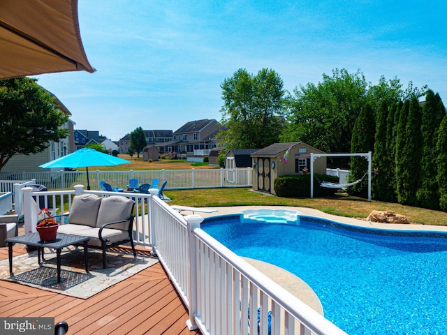 view of swimming pool featuring a storage shed, a yard, and a wooden deck