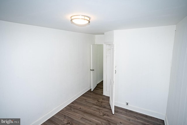 unfurnished room featuring dark wood-type flooring