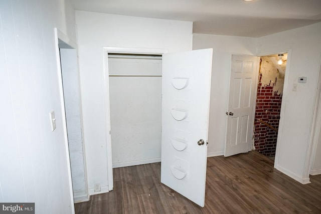 unfurnished bedroom with dark wood-type flooring and a closet