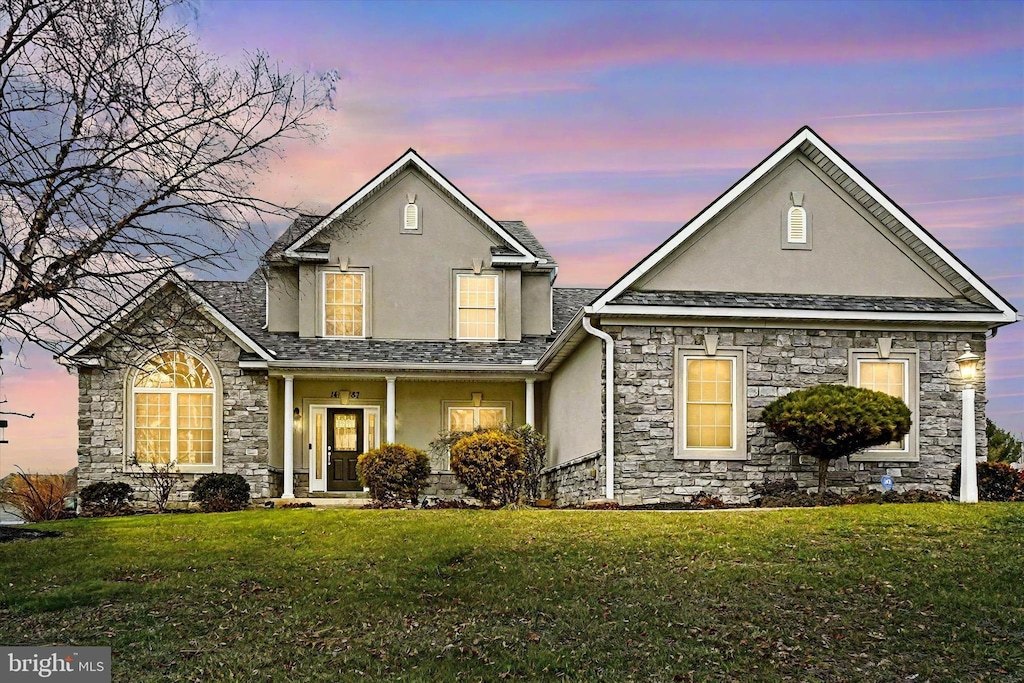 front of property with a porch and a lawn